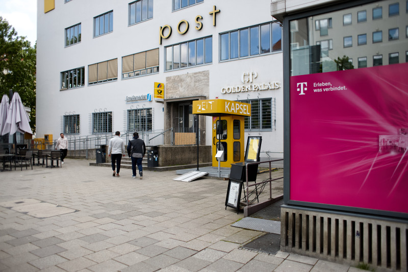 Ein Farbfoto von der ZEITKAPSEL, einer gelben Telefonzelle mit Dachkonstruktion (Aufschrift 